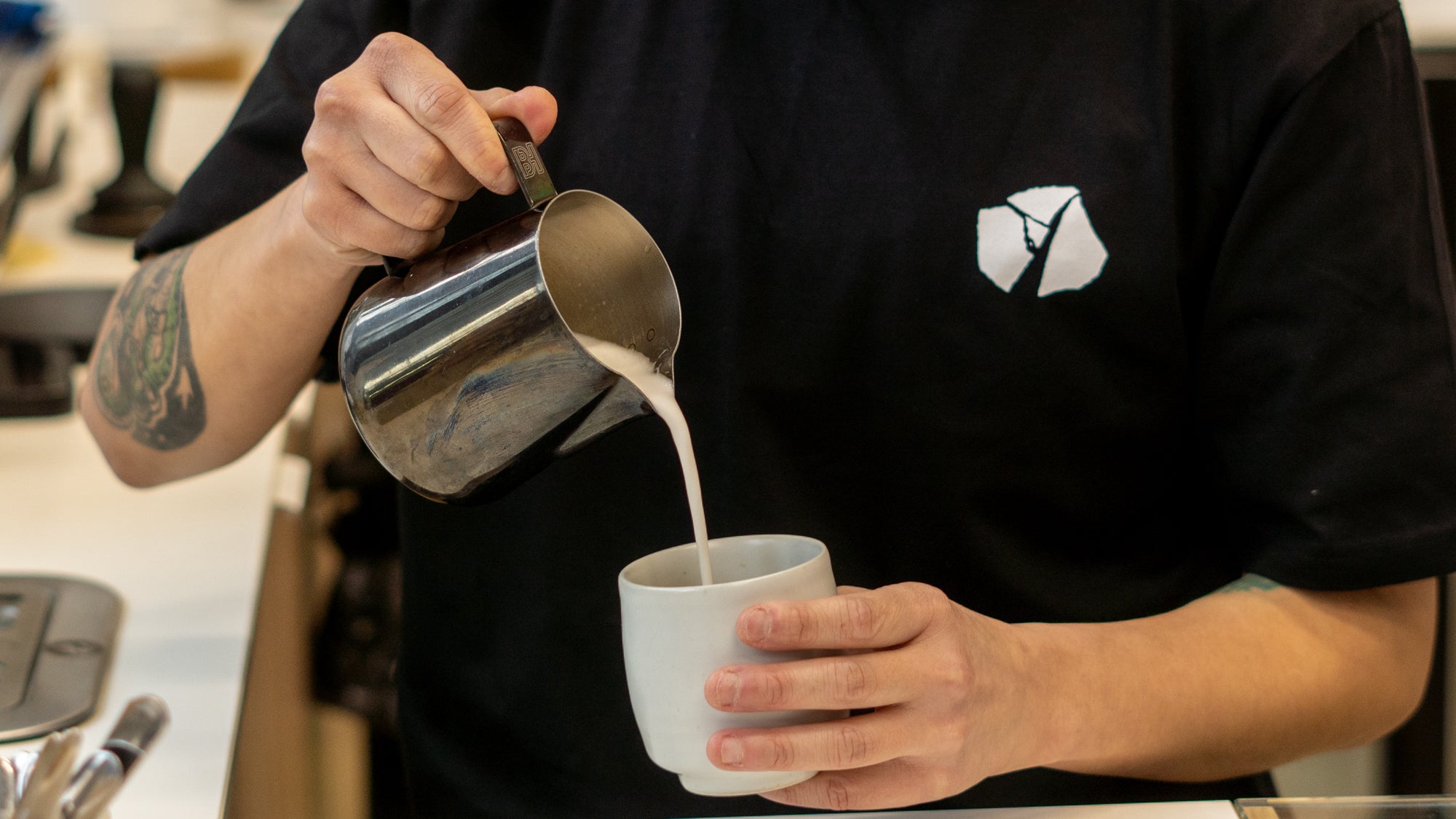 coffee helping homelessness woman with tattoo doing latte art