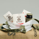 Old Spike tote bag filled with coffee, coffee pods, a travel tumbler and some hot chocolate